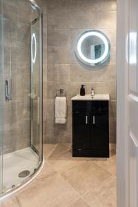 a bathroom with a shower and a sink and a mirror at No 1 Killarney Holiday Village Vacation Home in Killarney