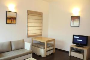 a living room with a couch and a table and a tv at AMC Comforts in Bangalore