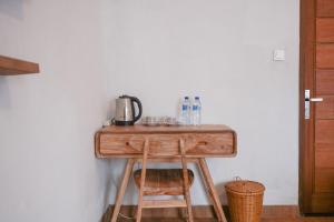 TampaksiringにあるUrbanview Villa Pondok Uma Sari near Ubudの木製テーブル、コーヒーメーカー付