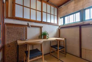 a room with a table and two stools at 抹香町ハウス in Odawara