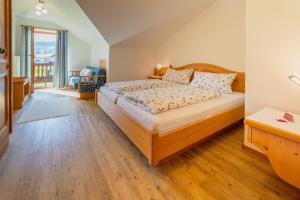 a bedroom with a large bed with a wooden floor at Ferienwohnung Westernberg in Ruhpolding