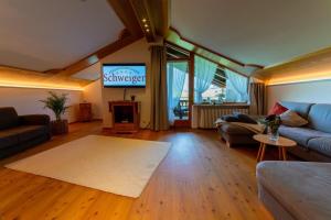 a living room with a couch and a tv at Ferienwohnung Westernberg in Ruhpolding