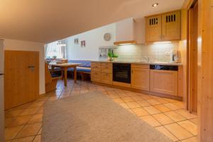a large kitchen with wooden cabinets and a table at Ferienwohnung Westernberg in Ruhpolding