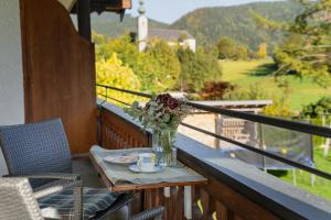 a table with a vase of flowers on a balcony at Wohnung Hochfelln in Ruhpolding