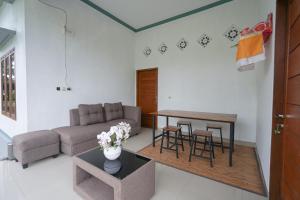 TampaksiringにあるUrbanview Villa Pondok Uma Sari near Ubudのソファとテーブルのあるリビングルーム