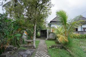 TampaksiringにあるUrbanview Villa Pondok Uma Sari near Ubudの家に通じる小道付きの庭園