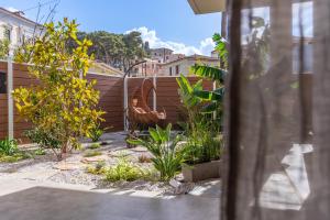 a garden with a roosteroster statue in a yard at Samos Tropic Apartments in Ríva