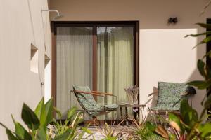two chairs and a table in front of a window at Samos Tropic Apartments in Ríva