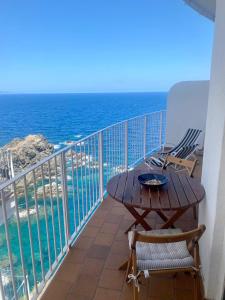 a balcony with a table and chairs and the ocean at El 66 de Cap Sa Sal in Begur