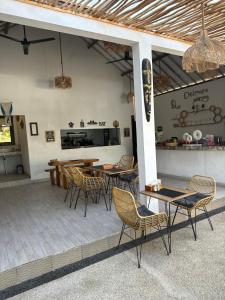 un patio con mesas, sillas y una barra en Delmora Home Balangan, en Uluwatu