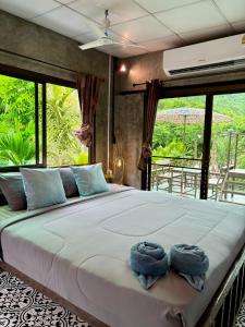 Ban Pong PatにあるBAAN APA ERAWAN Resortのベッドルーム1室(大型ベッド1台、タオル付)