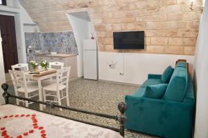 a living room with a blue couch and a table at B&B San Carlo in Laterza