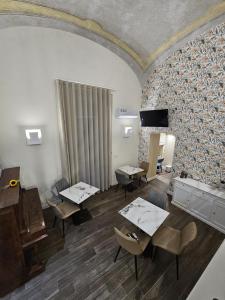 a room with tables and chairs and a piano at Napoli the charme in Naples