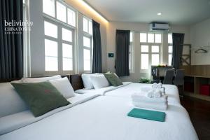 a large white bed with two teddy bears on it at Belivin99 Residence Chinatown in Bangkok