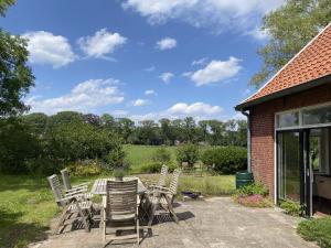 a patio with a bunch of chairs and a table at Vakantie Boerderij Oelewick in Winterswijk