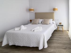 een slaapkamer met een wit bed met twee handdoeken erop bij Antonella Suites in Fuentes de Andalucía +13 foto's