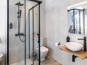 een badkamer met douche, toilet en wastafel bij Antonella Suites in Fuentes de Andalucía