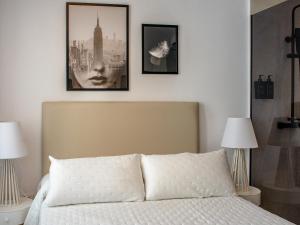 een slaapkamer met een bed met drie foto's aan de muur bij Antonella Suites in Fuentes de Andalucía