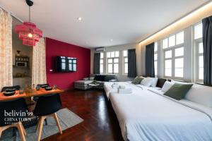 a living room with a large white bed and a red wall at Belivin99 Residence Chinatown in Bangkok +28 photos