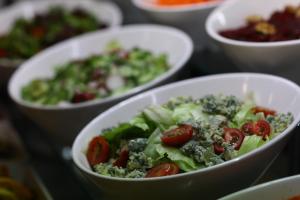 a bowl of salad with tomatoes and broccoli on a table at Arena Mar Hotel and SPA in Golden Sands