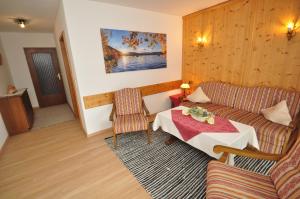 a living room with a couch and a table at Appartementhaus Alpenrose in Wallgau