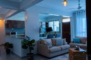 a living room with a couch and a kitchen at Halisi Nyali Lux Apartments in Mombasa