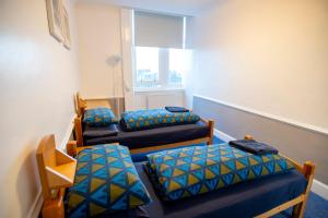 a room with three beds and a window at Glasgow Youth Hostel in Glasgow