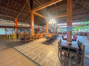 a restaurant with wooden tables and chairs in a building at RedDoorz at Damar Mas Gunung Kelud Kediri in Kediri