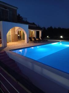 a swimming pool in front of a house at night at Villa San Silvestro in Oprtalj