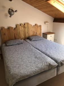 ein Schlafzimmer mit einem großen Bett mit einem hölzernen Kopfteil in der Unterkunft Villa OCELANDES in Saint-Julien-en-Born