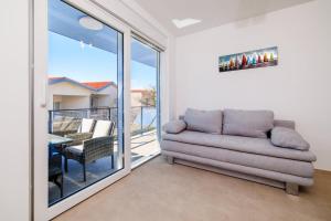 a living room with a couch and a balcony at Schmidt mali in Dramalj