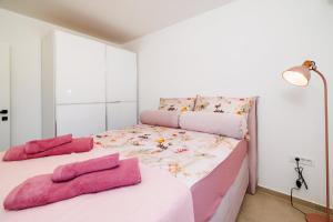 a bedroom with two beds with pink towels on them at Schmidt mali in Dramalj