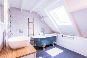 a bathroom with a blue tub and a sink at L'Olivera : entre évasion, sport et nature in Barneville-Carteret +17 photos