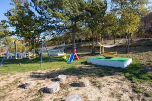 a playground with slides and swings in a park at Mobile Homes Romantik in Labin