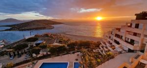 een uitzicht op het strand en de zonsondergang vanuit een gebouw bij SolDosMares Apartmentos in La Manga del Mar Menor