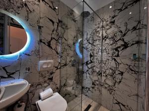 a bathroom with a shower and a sink at Dine Hotel in Ksamil +37 photos