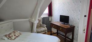 una camera con un letto e una televisione su un tavolo di La Cour Du Puits Chambre Victor a Cormeilles