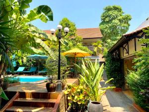 a house with a pool and a street light with plants at Ra-Ta Boutique Hotel in Siem Reap