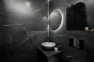 un baño con lavabo y espejo en Urban Apartament, en Chişinău 13 fotos más
