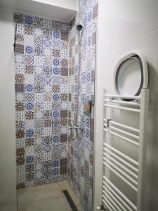 a bathroom with a shower with blue and white tiles at New apartment in Skopje Center - FREE Private Parking in Skopje