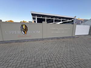 a wall with a sign on it in front of a building at Upper Room Guesthouse in Kirkwood