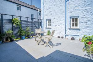 two chairs and a table in front of a building at Sea Glass - 2 Bedroom Apartment - Manorbier in Manorbier