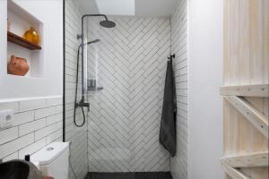 a bathroom with a shower with a white tiled wall at Apartamento Pitaya in Arrecife +15 photos