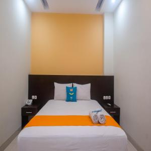 Uma cama ou camas num quarto em Sans Hotel Nagari Malioboro