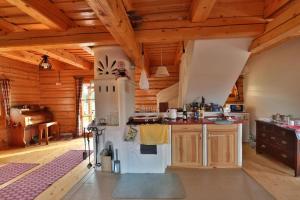 a kitchen with a white refrigerator and wooden ceilings at Mountain View Cottage in Hrabušice