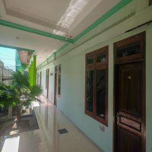 un pasillo de un edificio con una puerta y una planta en RedDoorz Plus @ Timoho, en Yogyakarta