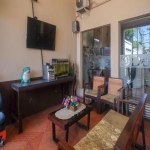 sala de estar con TV, mesa y sillas en RedDoorz Plus @ Timoho, en Yogyakarta