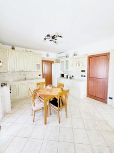 una cucina con tavolo e sedie in legno di Terrazzo Privato, Salento, sul Mare a Torre Ovo