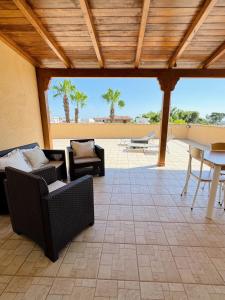 un patio con divani, tavolo e sedie di Terrazzo Privato, Salento, sul Mare a Torre Ovo