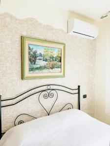 una camera da letto con un letto e un quadro sul muro di Terrazzo Privato, Salento, sul Mare a Torre Ovo